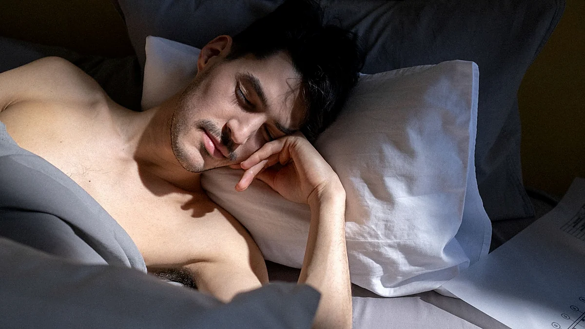 Man sleeping in natural morning light in a quiet bedroom